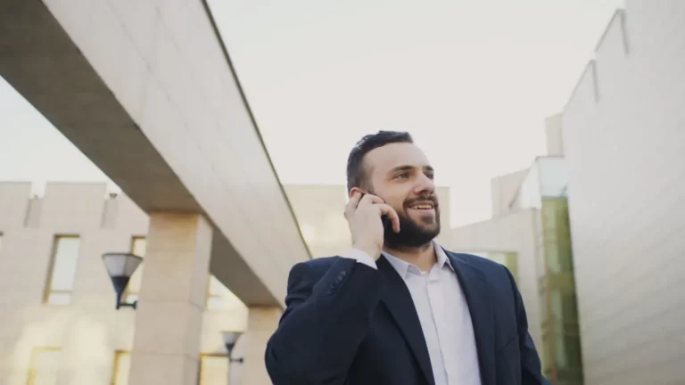 Professionnel au téléphone devant un immeuble de bureau
