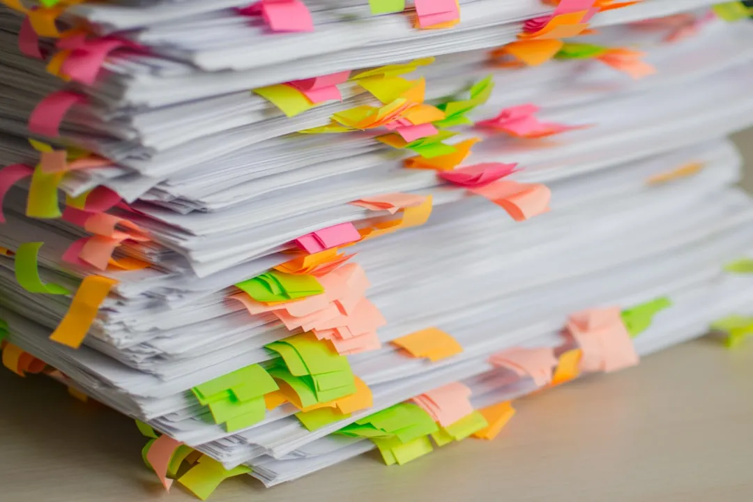 Pile de documents avec post-its colorés