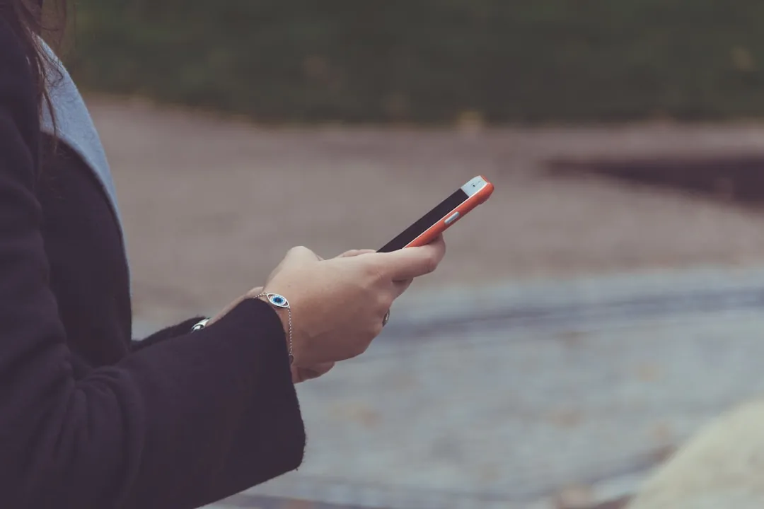 Personne consultant son smartphone en extérieur