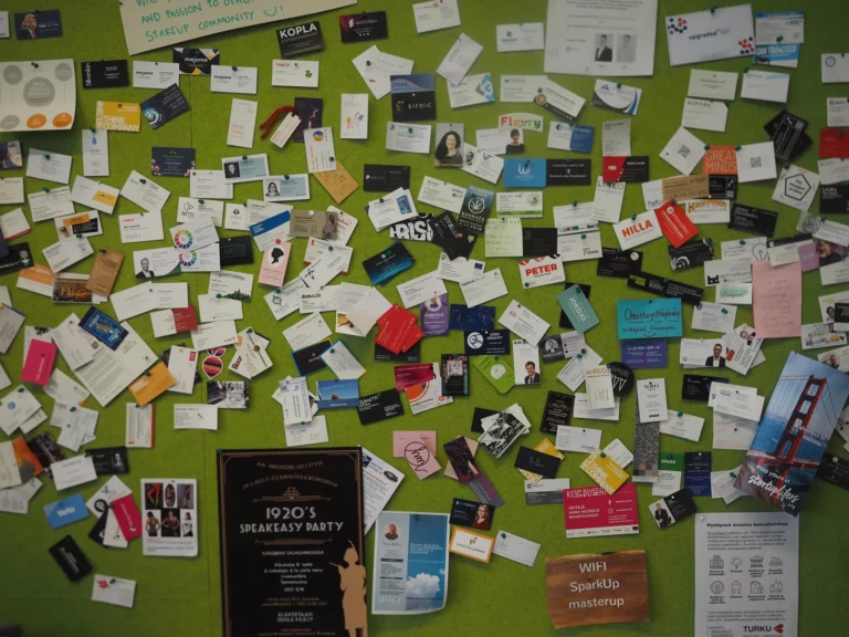 Mur couvert de dizaines de cartes de visite papier épinglées de manière chaotique, illustrant l accumulation et le désordre du networking papier