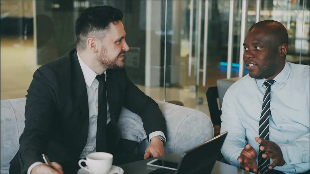 Deux professionnels discutant dans un lobby moderne